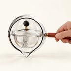360° Rotating Glass Teapot on a warm ivory studio background