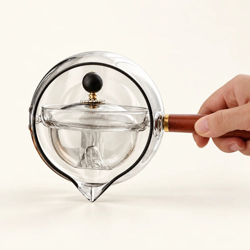 360° Rotating Glass Teapot on a warm ivory studio background