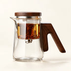 Glass Infuser Teapot with Wood Handle on a warm ivory studio background