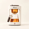 Automatic Glass Tea Maker with Keep-Warm on a warm ivory studio background
