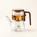 Glass Infuser Teapot with Wood Handle on a warm ivory studio background