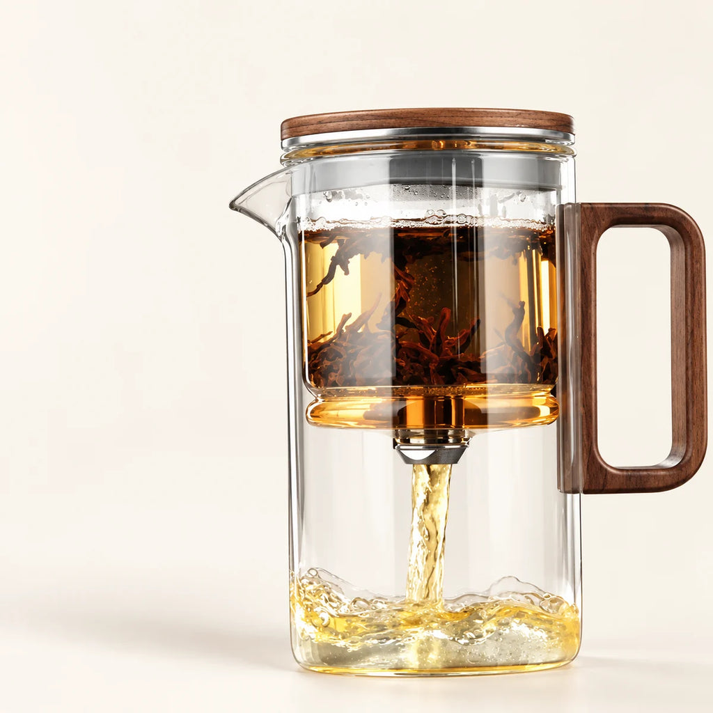 Glass Tea Brewer with Wood Handle on a warm ivory studio background