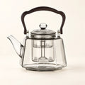 Octagonal Glass Tea Kettle on a warm ivory studio background